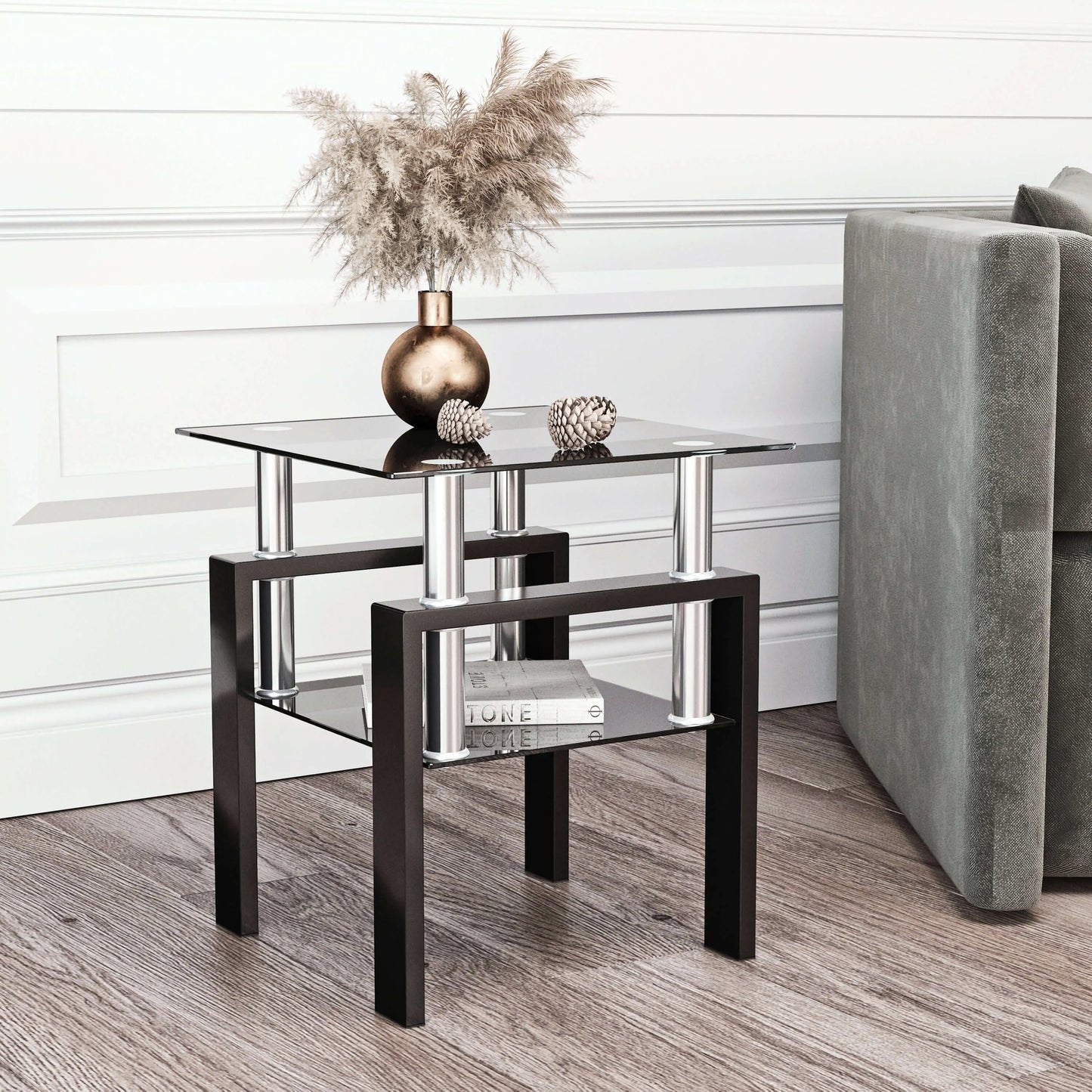 Modern end table with glass top and shelf with black metal legs in a living room setting.