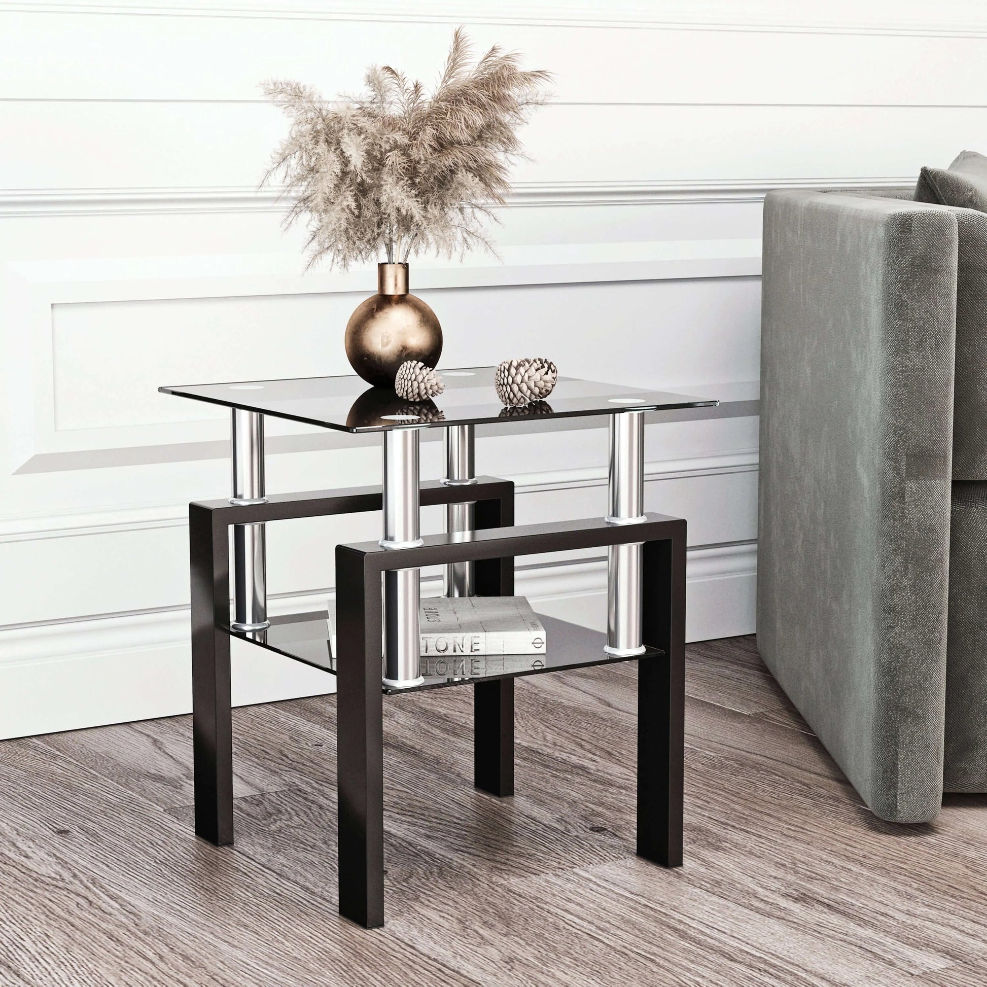 Modern end table with glass top and black metal legs in a living room setting.