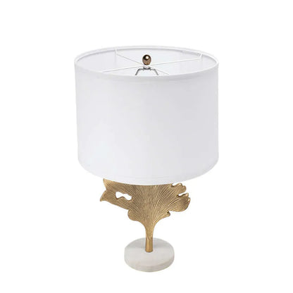 Table lamp with white shade , gold leaf and white marble base on a white background