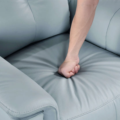 Person's fist resting on a blue recliner chair seat cushion