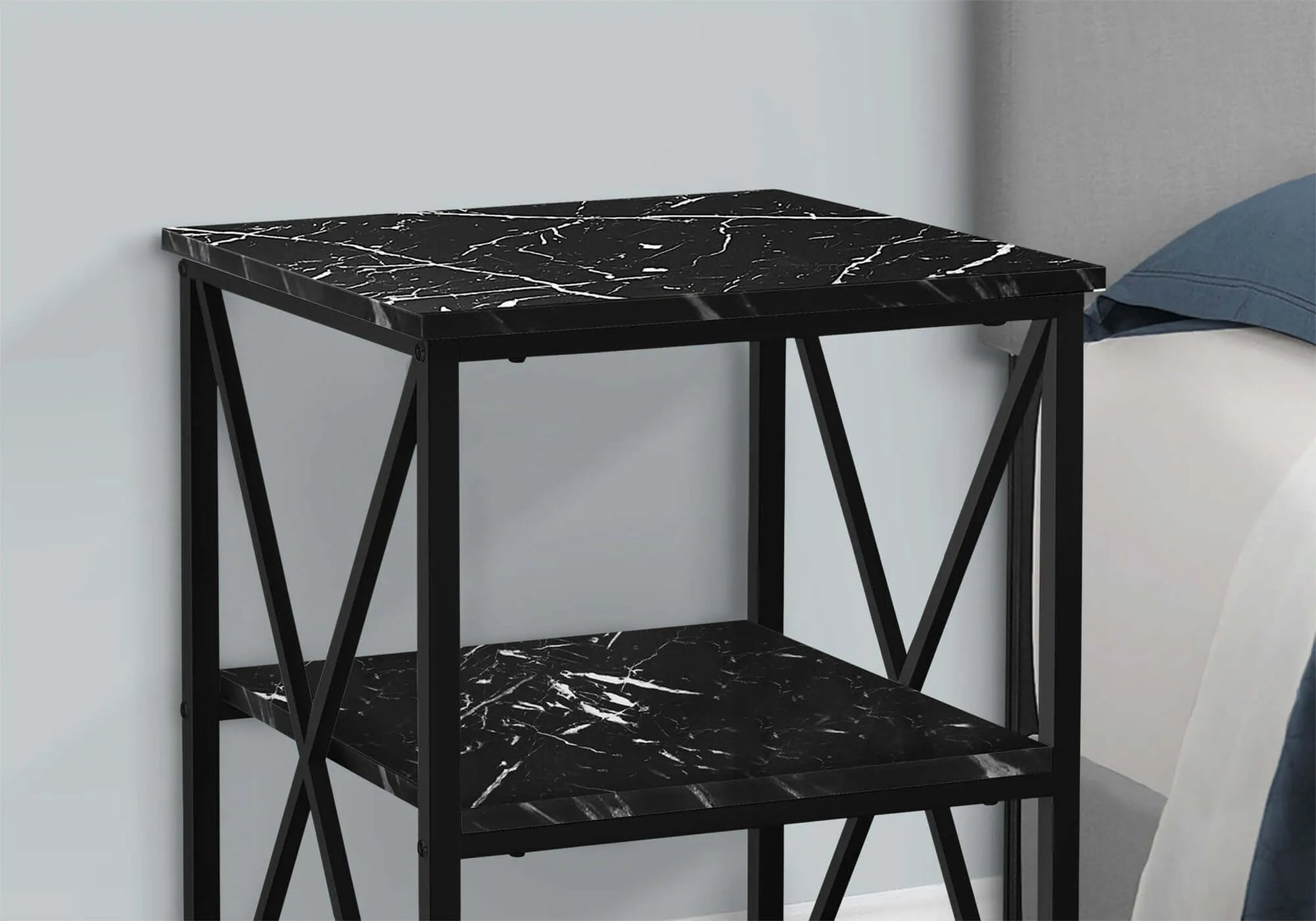 Black marble-patterned end table against a light gray wall.