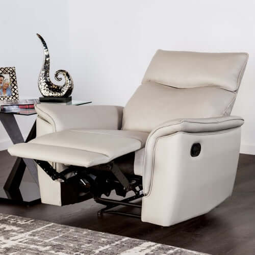 Beige leather recliner chair in a reclining position in a room with a decorative table and abstract sculpture.