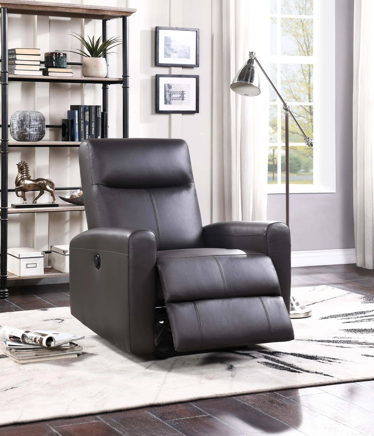Brown leather recliner chair in a living room setting with a bookshelf and lamp.