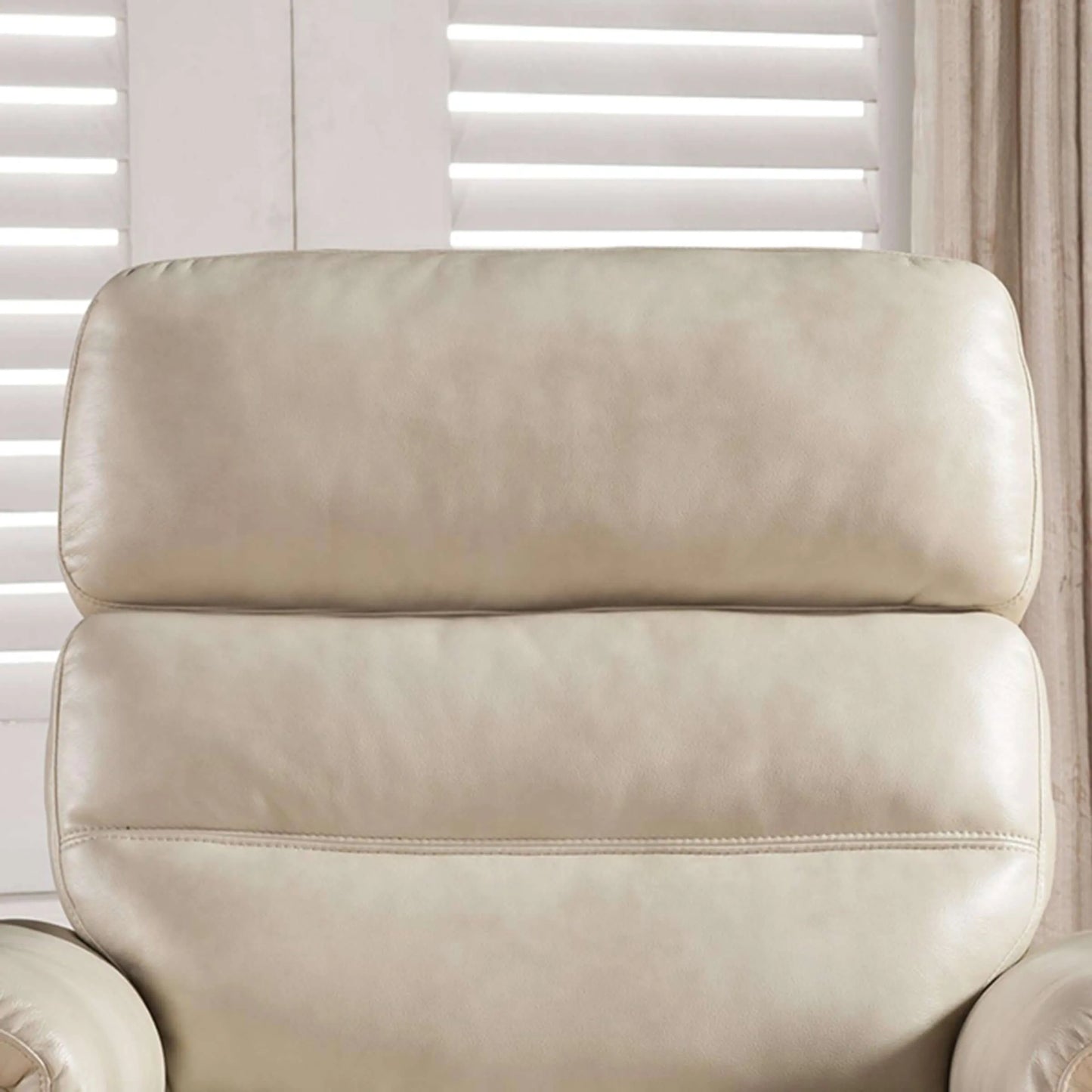 Close up of cushions on a cream color recliner chair with a neutral background
