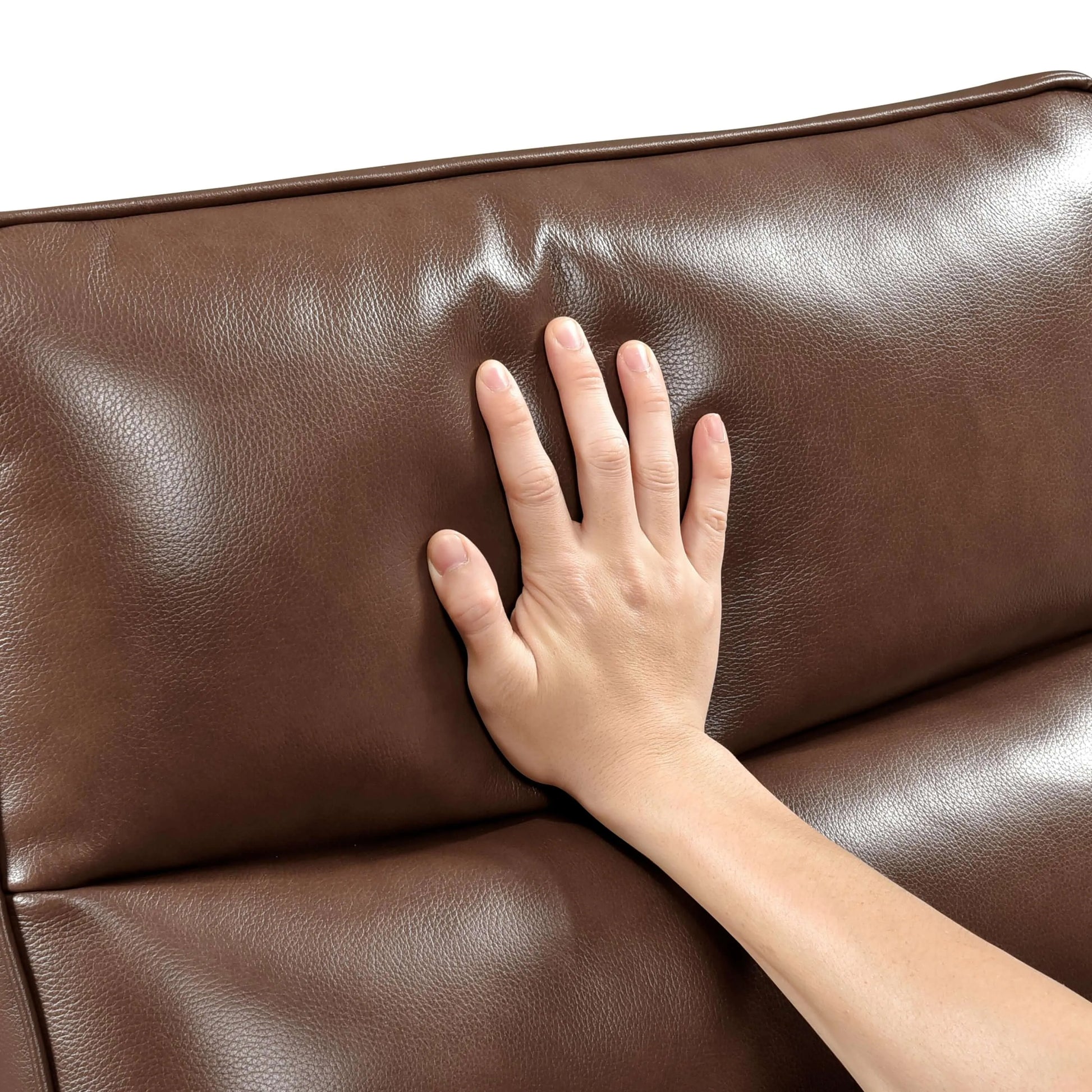 Hand touching a brown leather recliner chair cushion on a white background