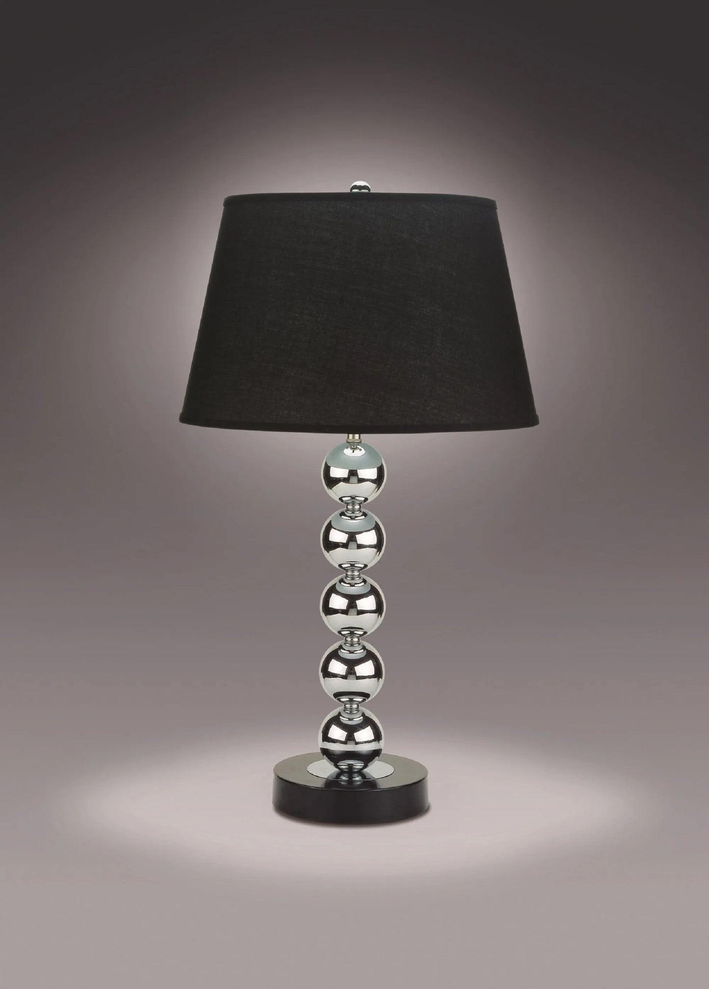 Table lamp with black shade and silver base on a dark background