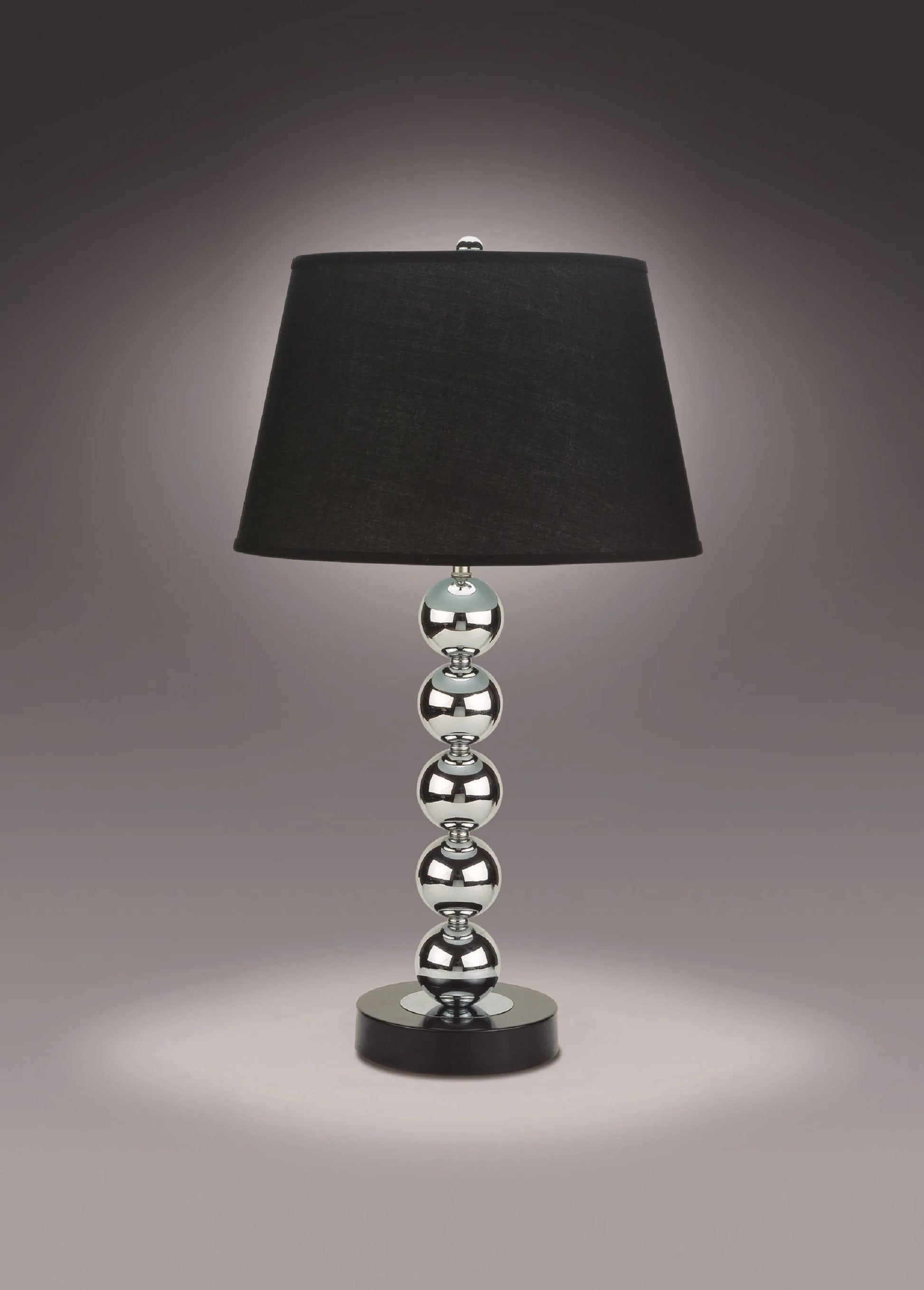 Table lamp with black shade and silver base on a dark background
