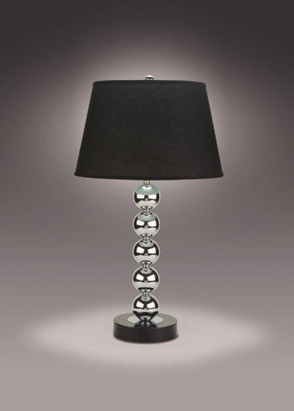 Table lamp with black shade and silver base on a dark background