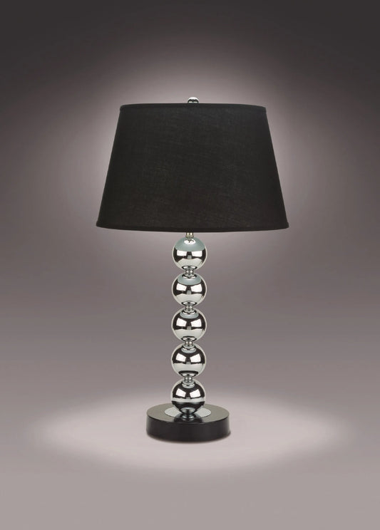 Table lamp with black shade and silver base on a dark background
