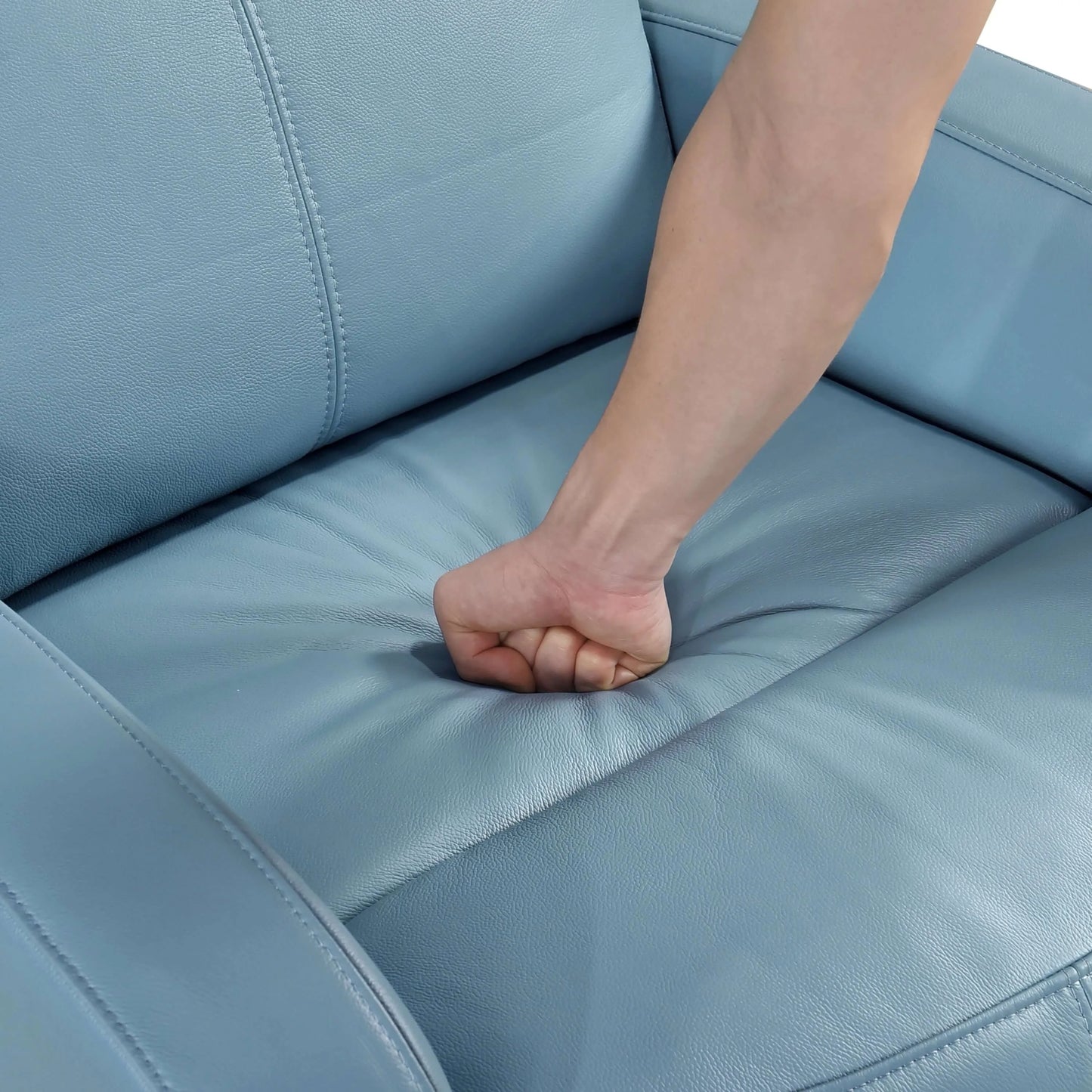 Hand pressing down on a blue recliner chair seat cushion