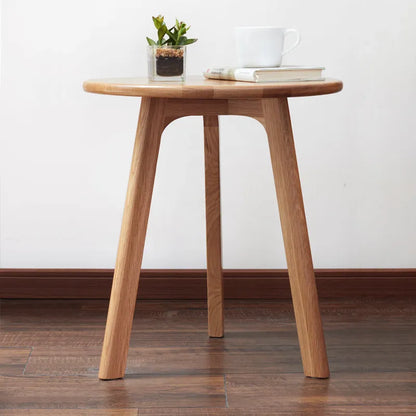 Wooden accent table with a plant and books on a white wall background