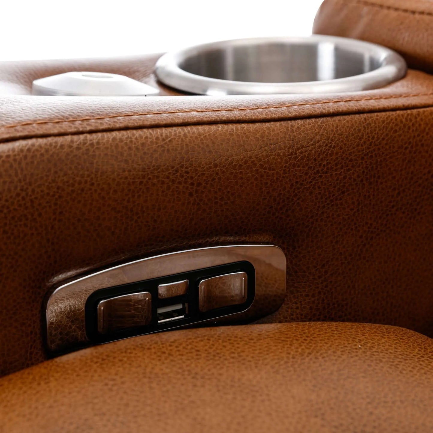 Close-up of a brown leather recliner chair cup holder and control buttons with a metallic finish.