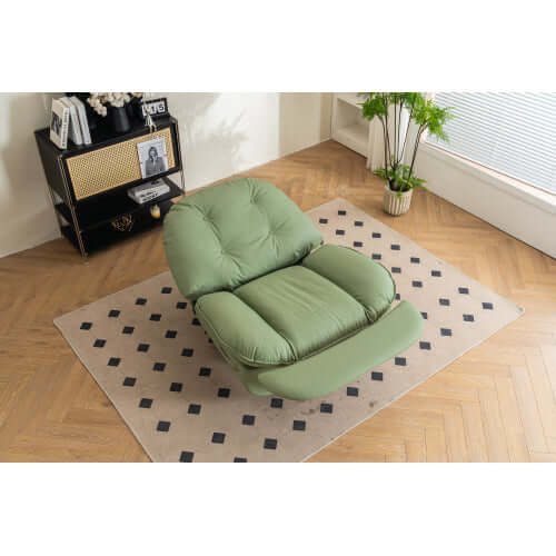 Green leather reclining chair on a patterned rug in a room with wooden flooring and a window.