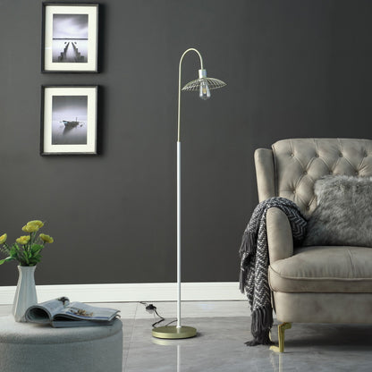 Modern living room with a gray armchair, floor lamp, and framed pictures on a dark gray wall.