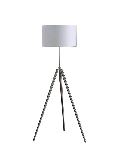 Tripod floor lamp with silver metal legs with a white shade on a white background