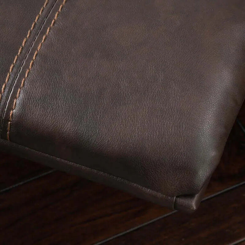 Close-up of a footrest on a brown faux leather glider recliner with stitching detail