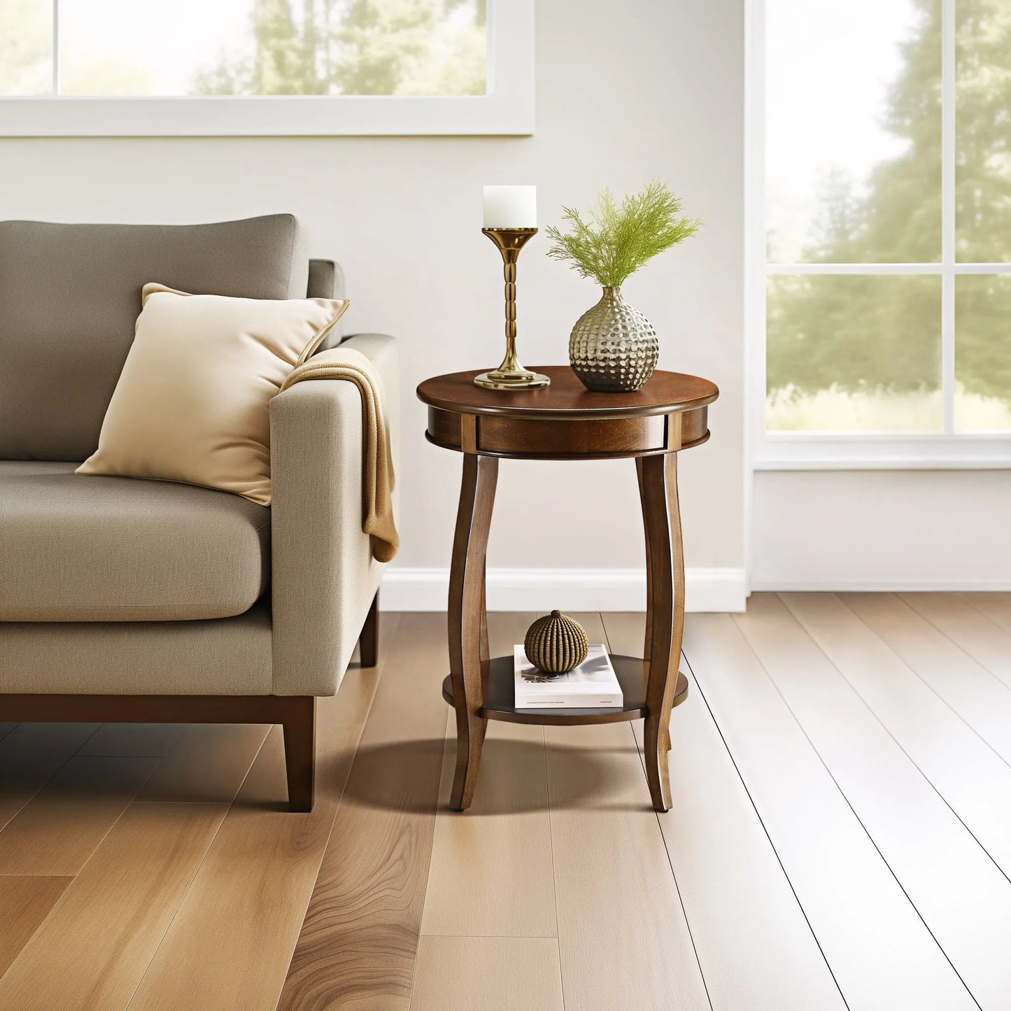 Round walnut wood end table with decorative items next to a gray sofa in a bright living room.