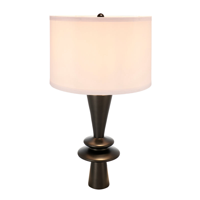 Table lamp with a white shade and bronze base on a white background