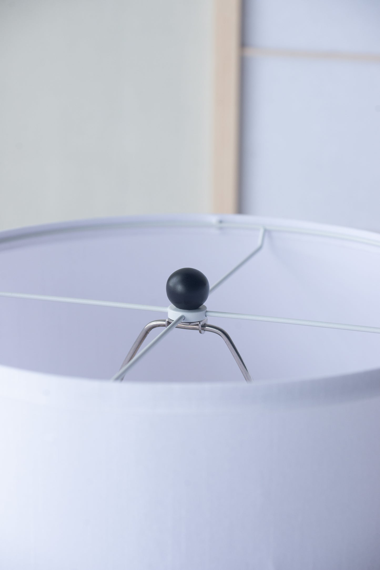 Close-up of a lampshade with a black finial and white background