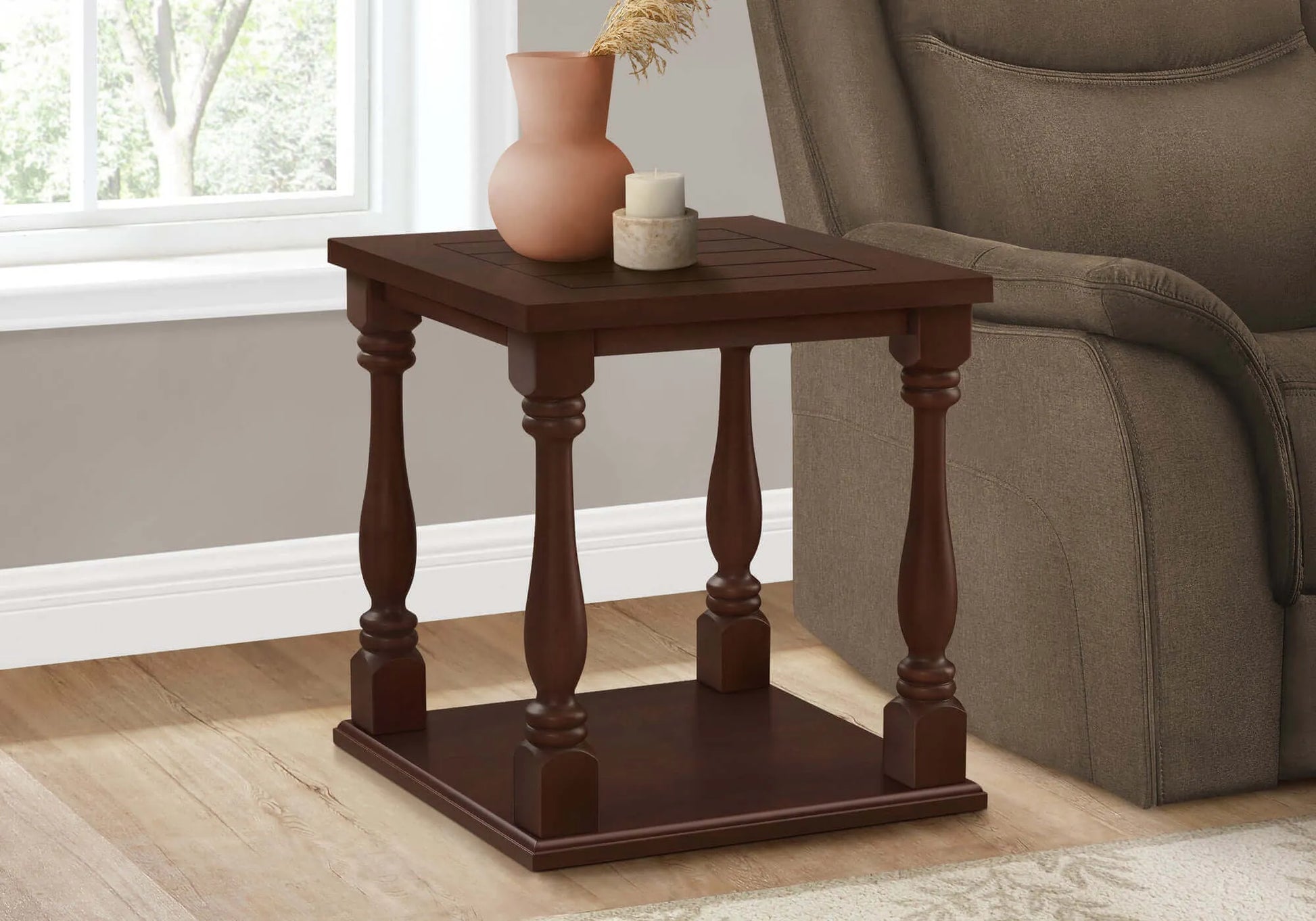 Wooden accent table with decorative items next to a sofa in a living room.