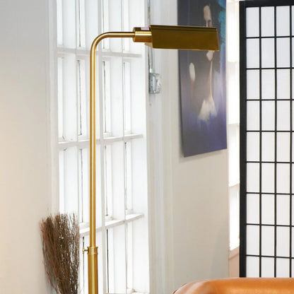 Brass floor lamp in a room with a window and decorative elements.