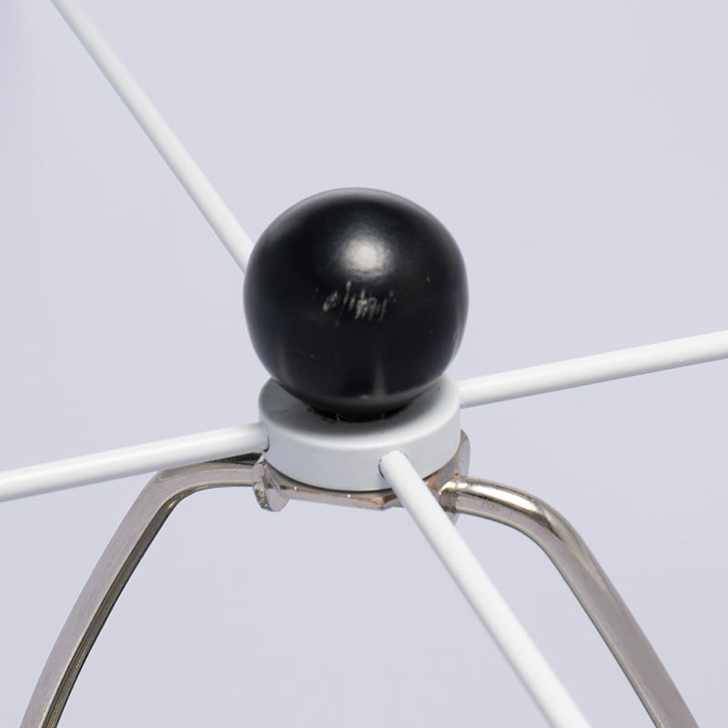 Close-up of a metal light frame with a black ball attachment on a light gray background