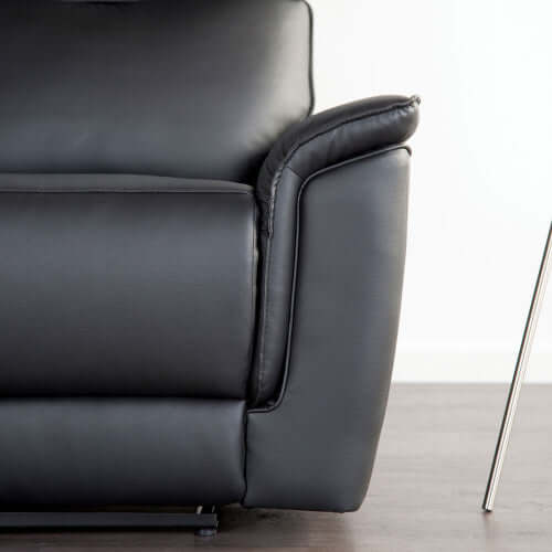 Close-up of a black leather armchair on a light background