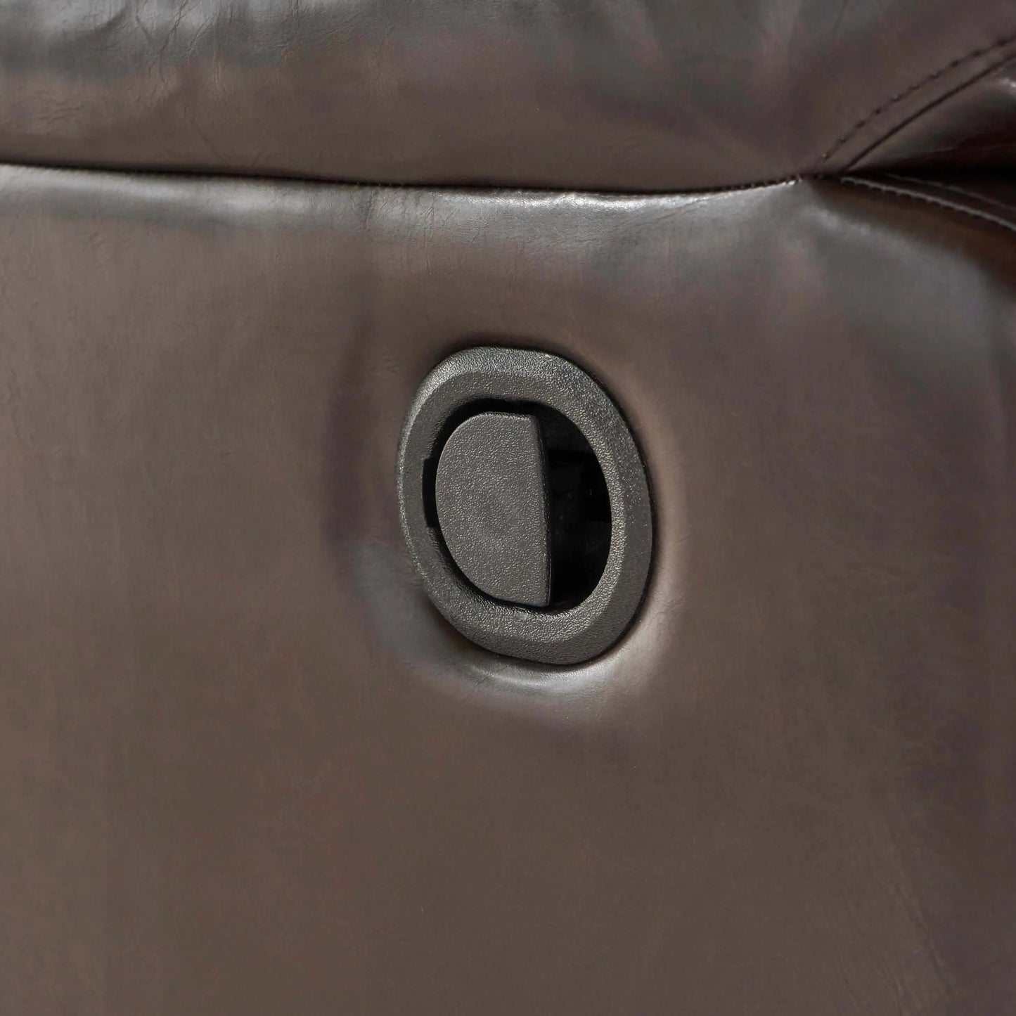 Close-up of a brown leather reclining chair button.