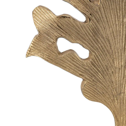 Close-up of a textured gold leaf design on a white background