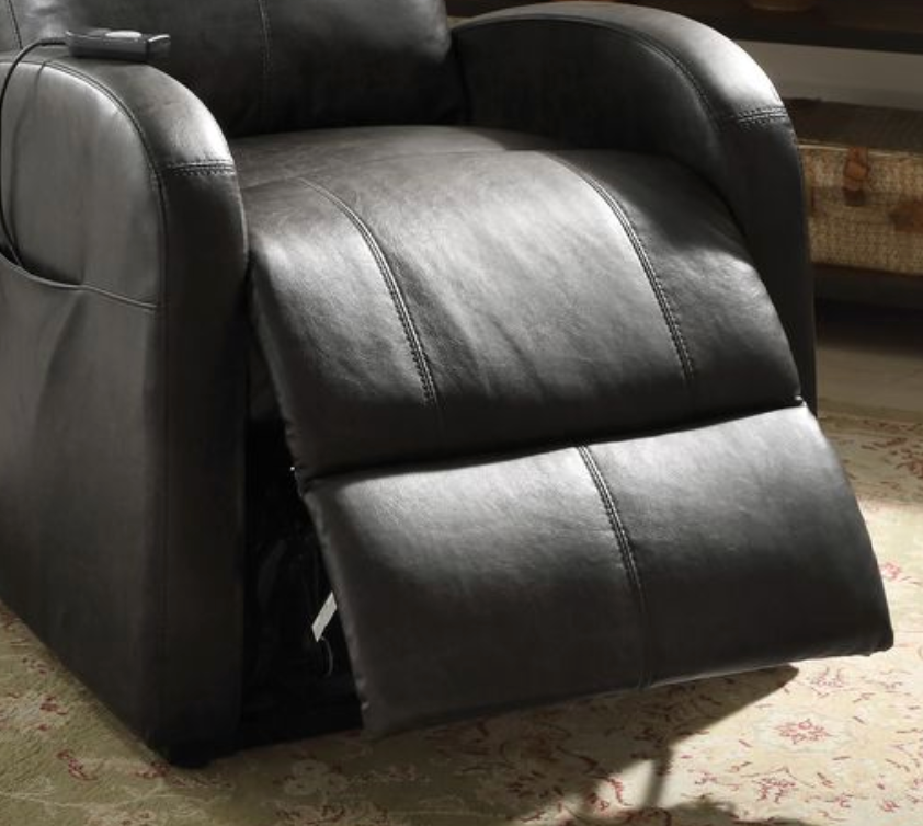 Close up of a dark brown faux leather recliner chair footrest slightly extended on a patterned rug