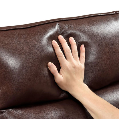 Hand touching a brown leather recliner chair back cushion.