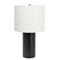 Table lamp with a black base and white drum shade on a white background