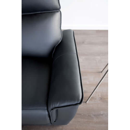 Black leather recliner chair corner on a wooden floor
