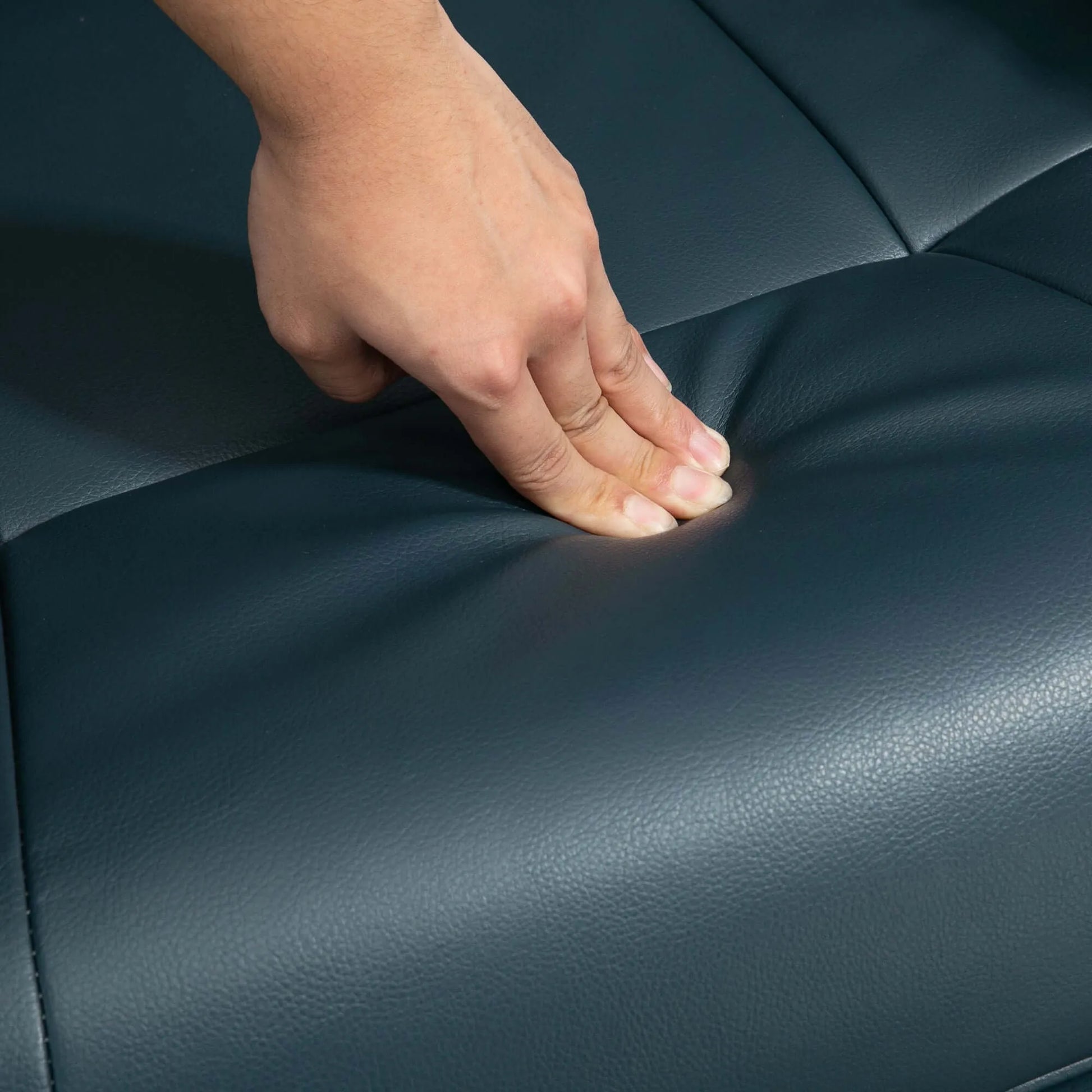 Hand touching a blue recliner chair seat cushion