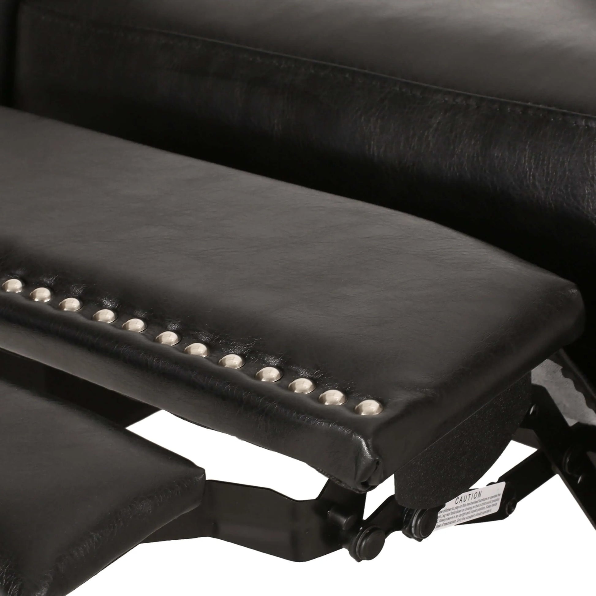 Close up of a black leather recliner chair footrest with studded detail on a white background