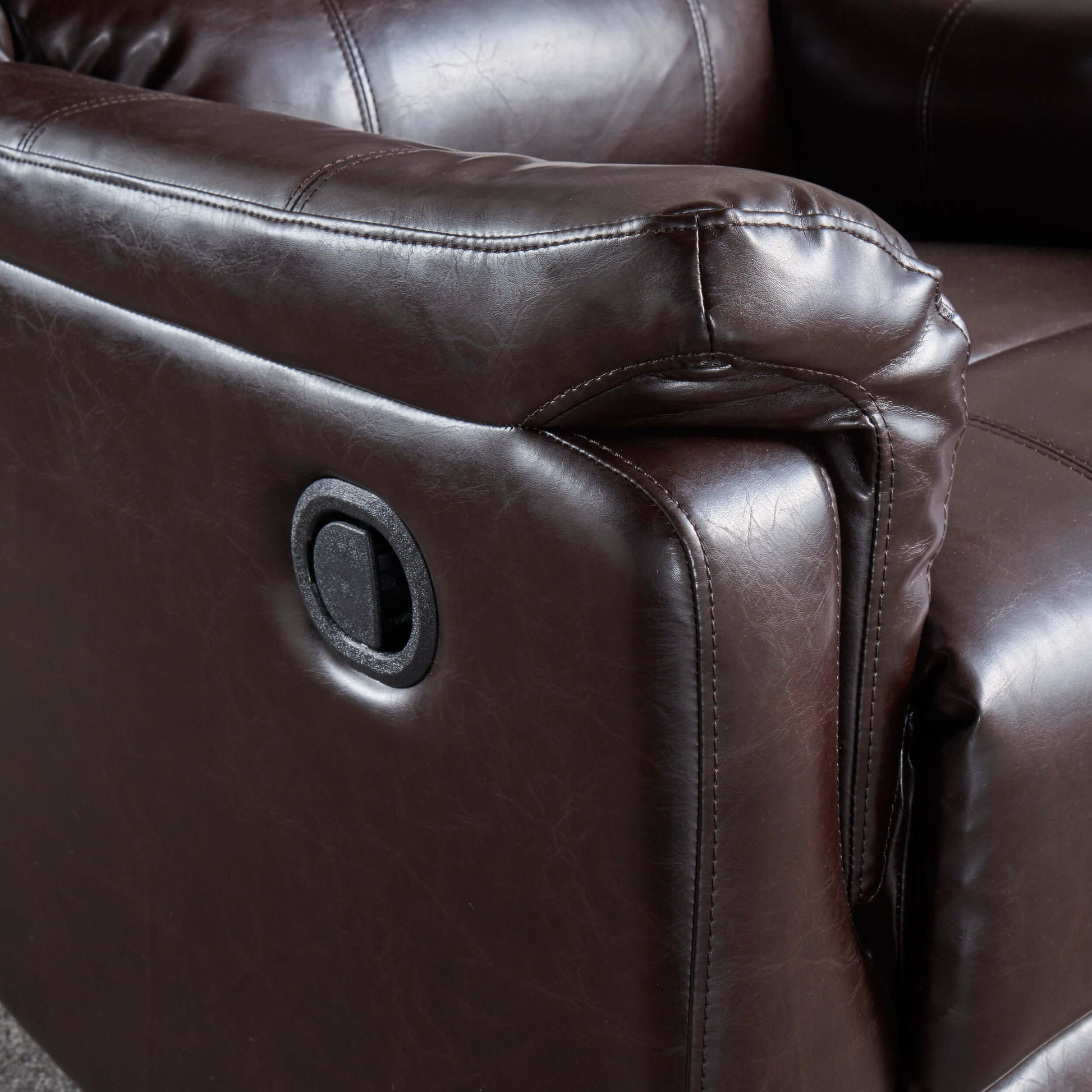 Close-up of a brown leather recliner chair with a focus on texture and stitching.