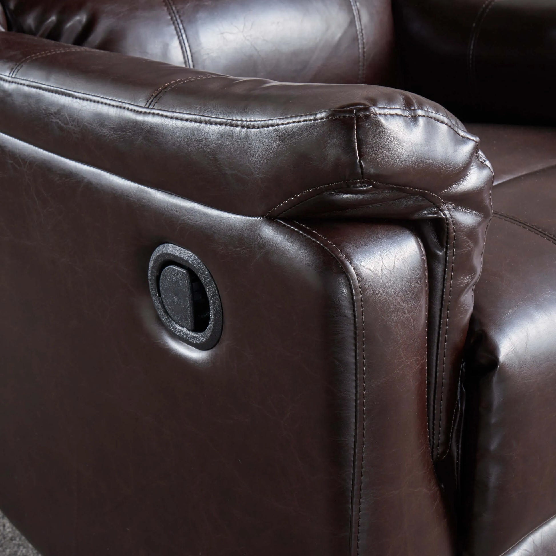 Close-up of a brown leather recliner chair with a focus on texture and stitching.