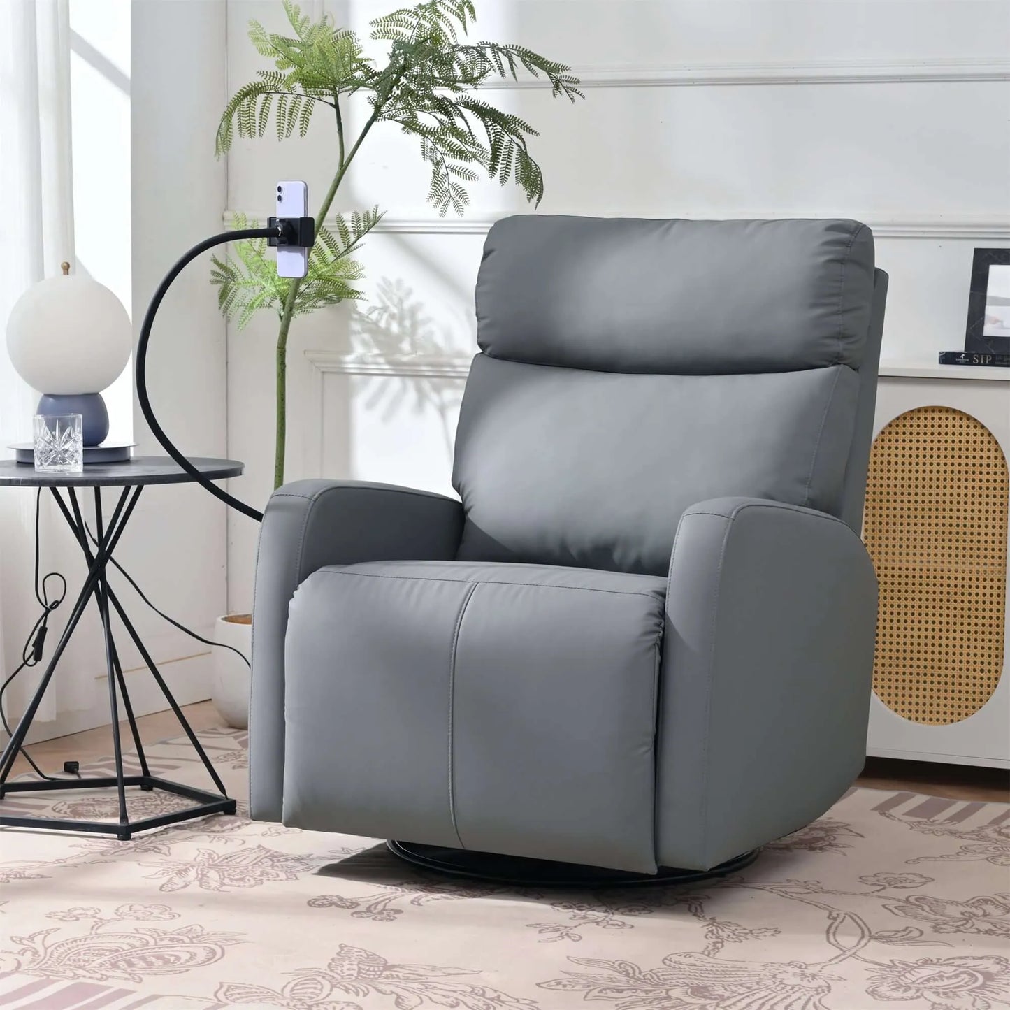 Gray recliner chair holding a phone in a living room setting with a plant and side table.