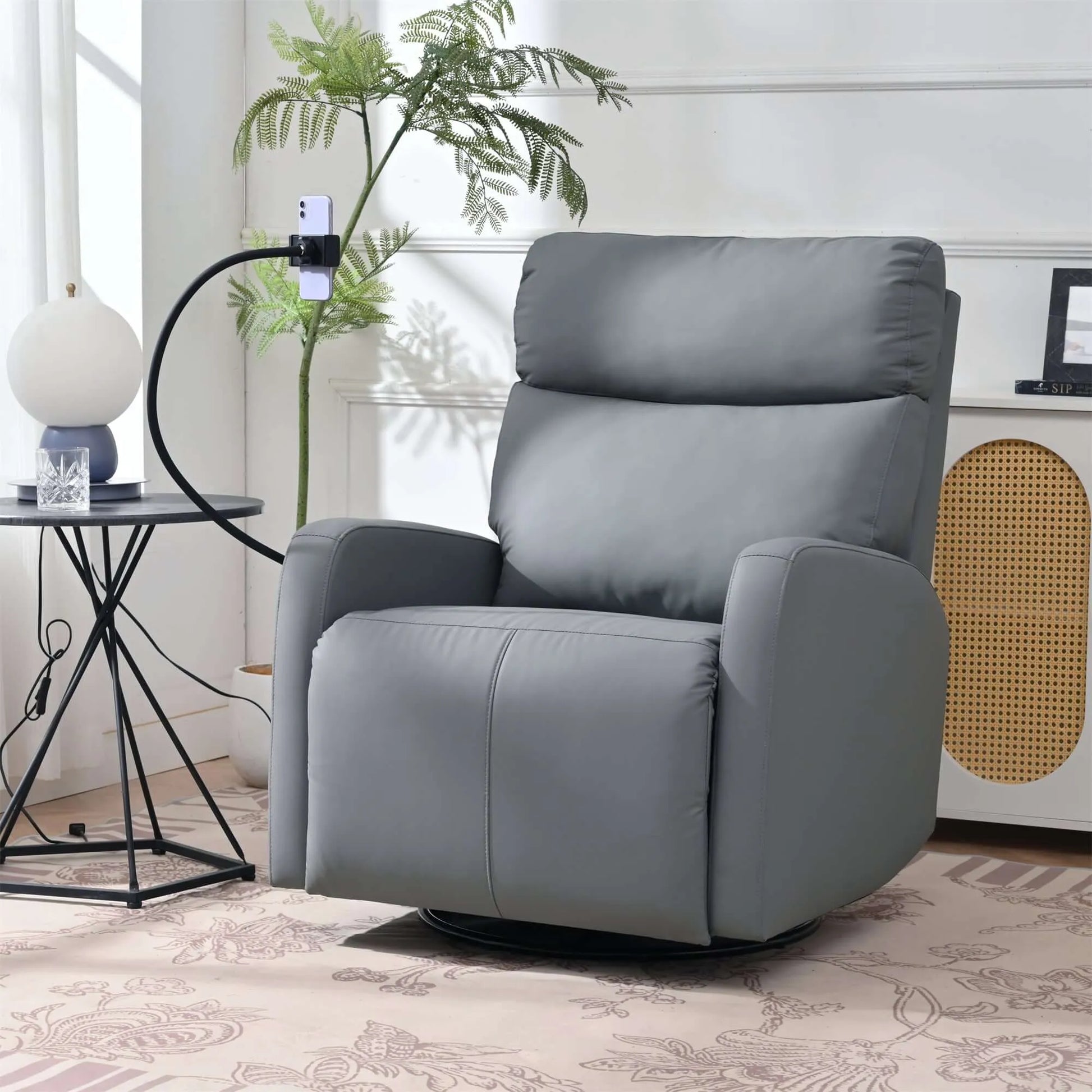 Gray recliner chair holding a phone in a living room setting with a plant and side table.