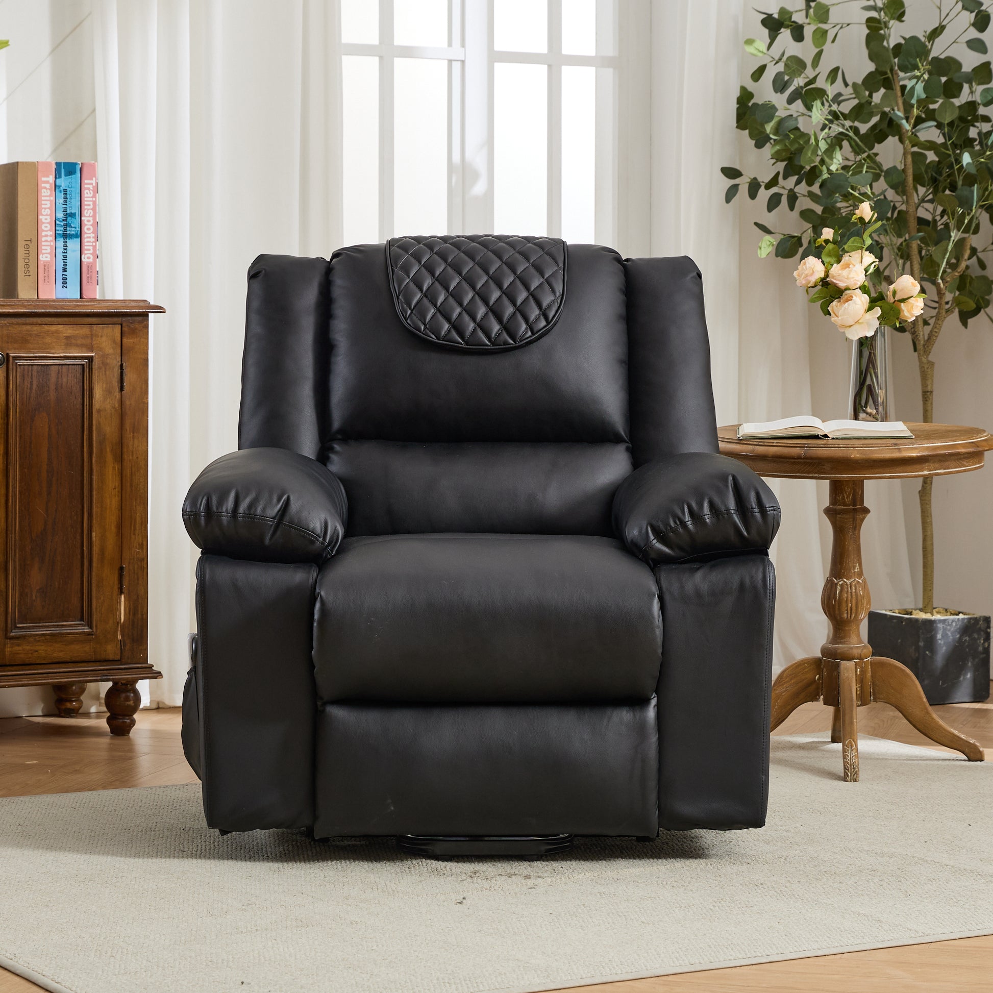 Black leather recliner chair in a living room setting with a wooden cabinet and table.