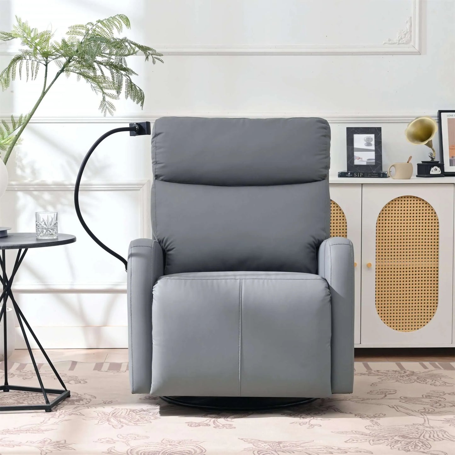 Front view of a gray recliner chair in a room with a plant and side table.