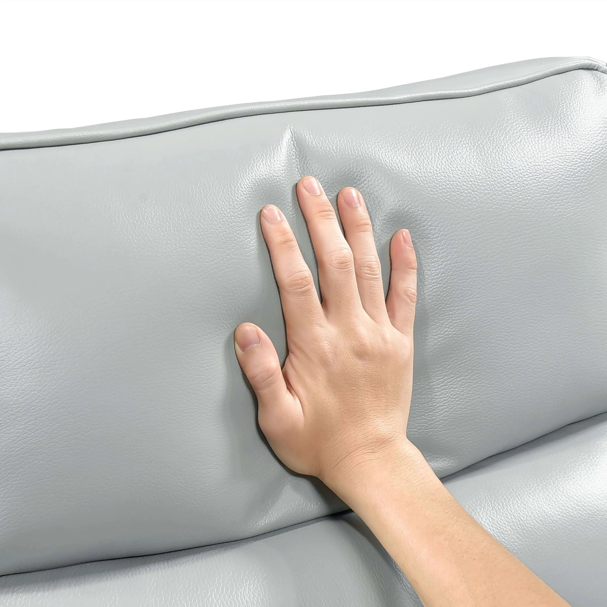 Hand touching a light blue leather recliner chair back cushion on a white background