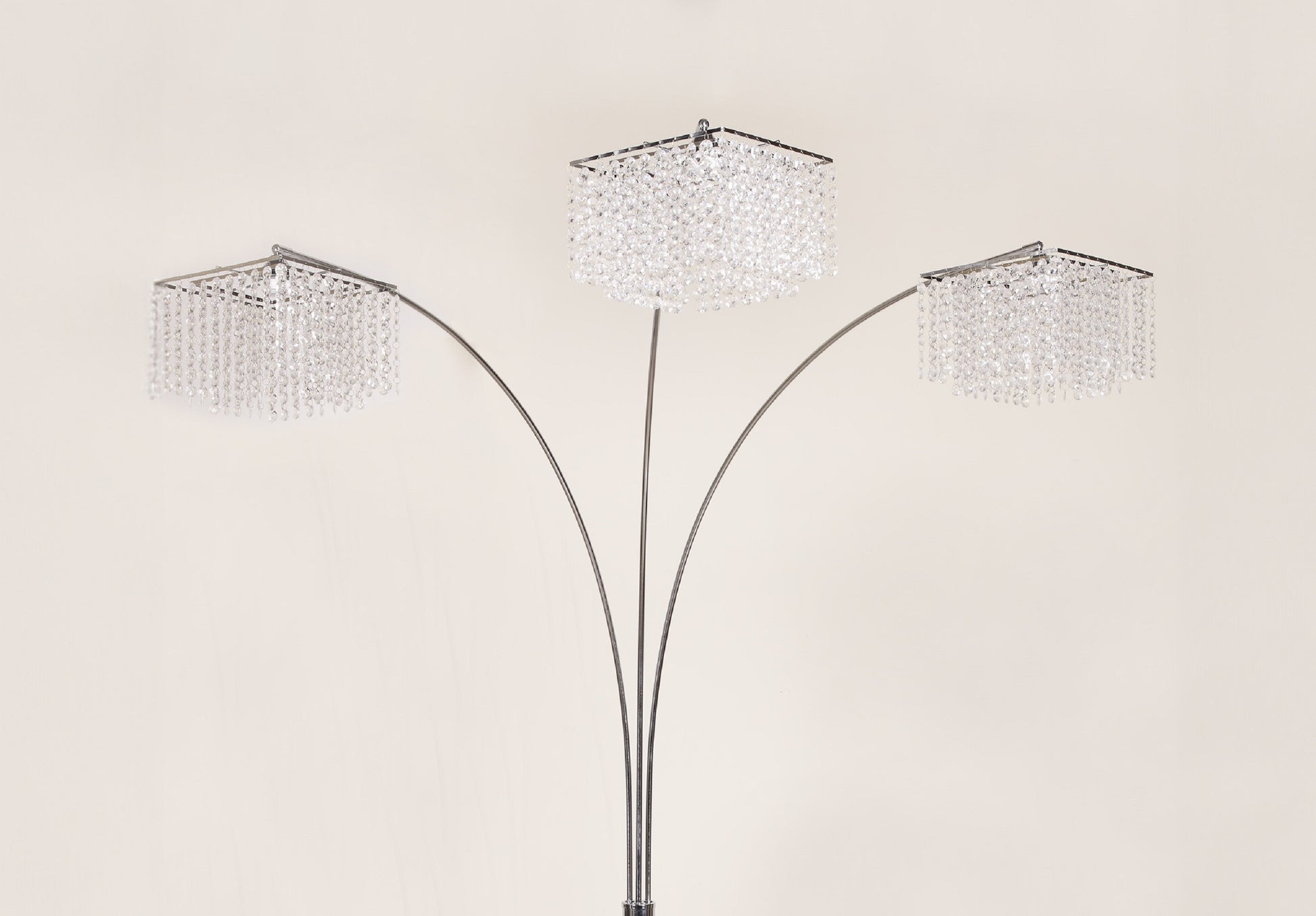Three-tiered floor lamp with crystal-like shades on a beige background
