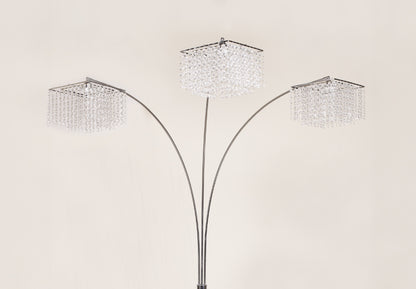 Three-tiered floor lamp with crystal-like shades on a beige background