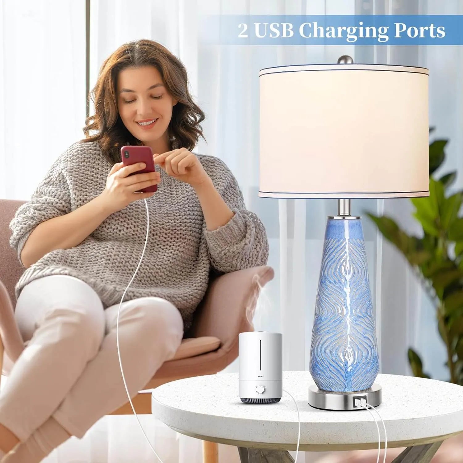 Woman using a smartphone with a blue and white lamp and diffuser on a table.