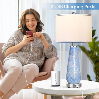 Woman using a smartphone with a blue and white lamp and diffuser on a table.
