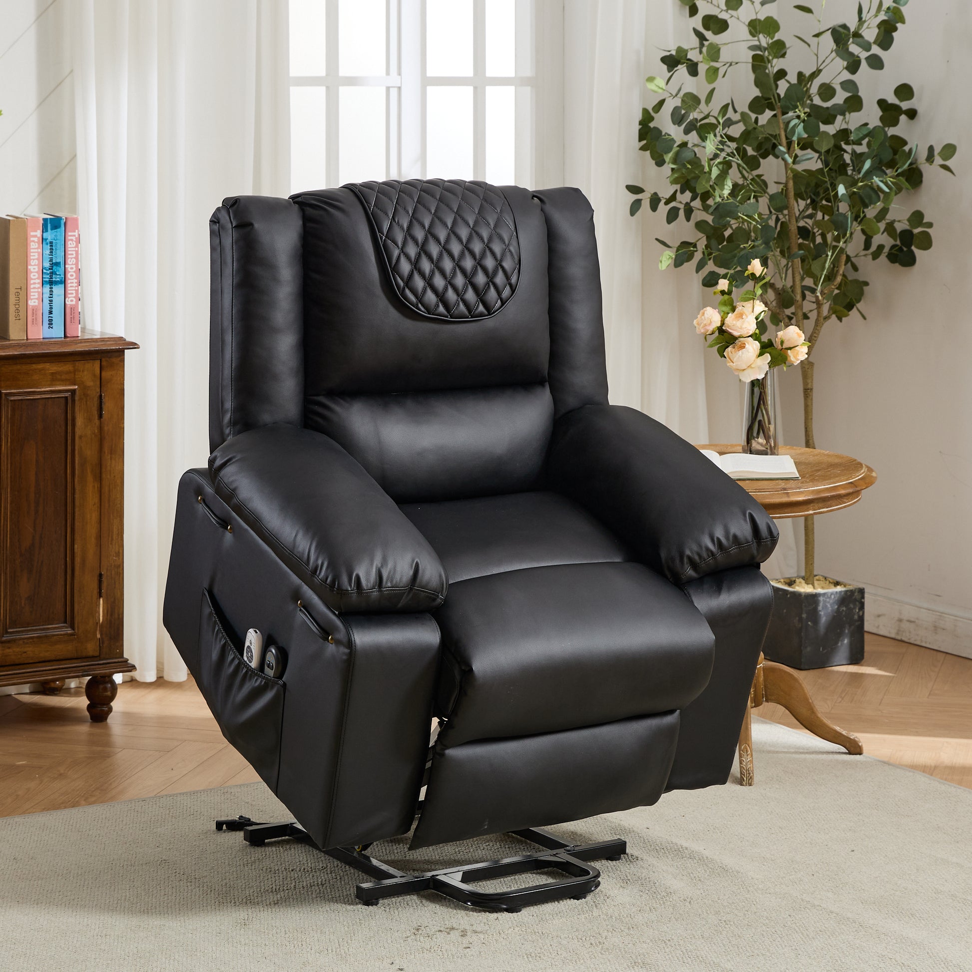 Black leather recliner chair in a living room setting with a plant and books in the background.