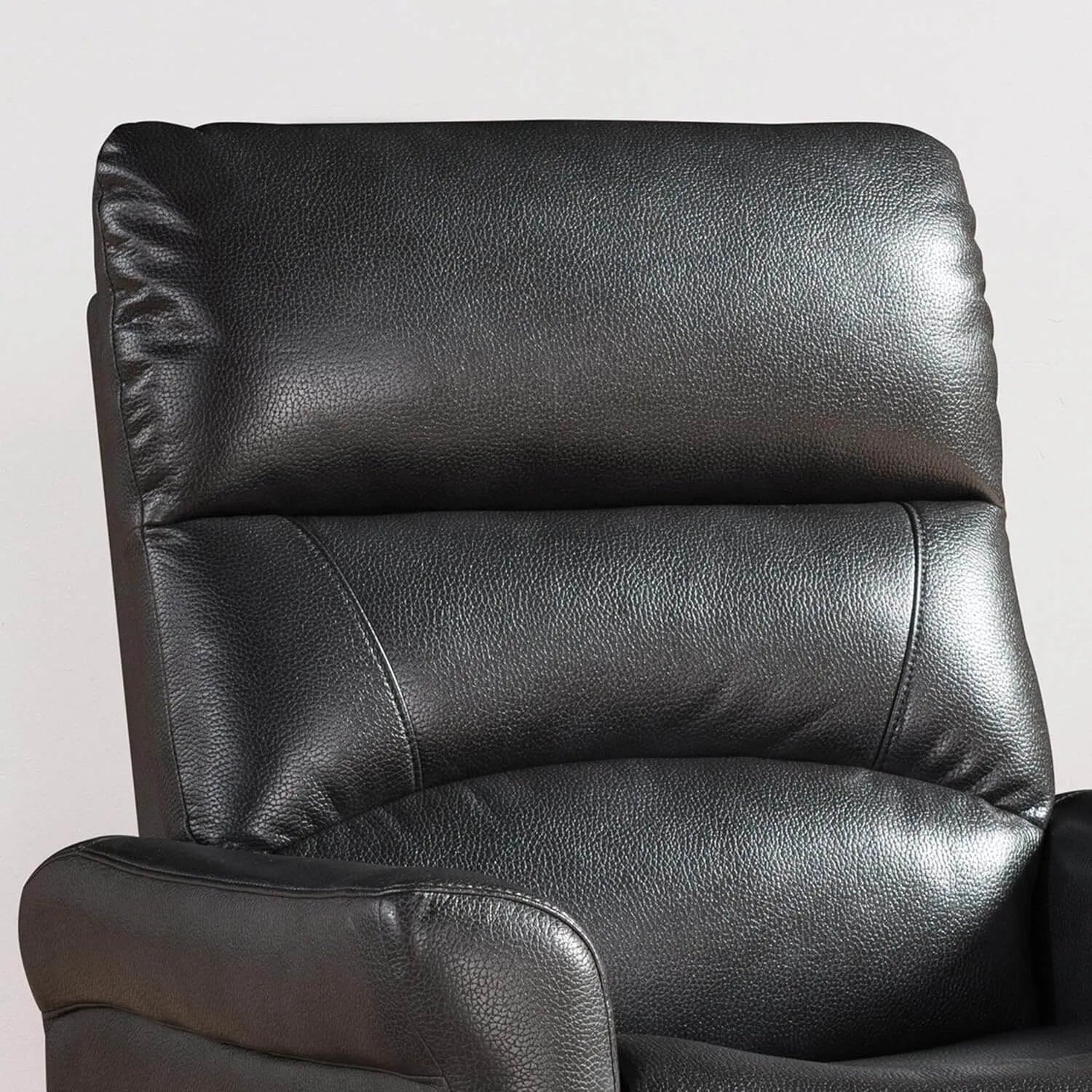 Close-up of a black faux leather recliner chair on a light gray background