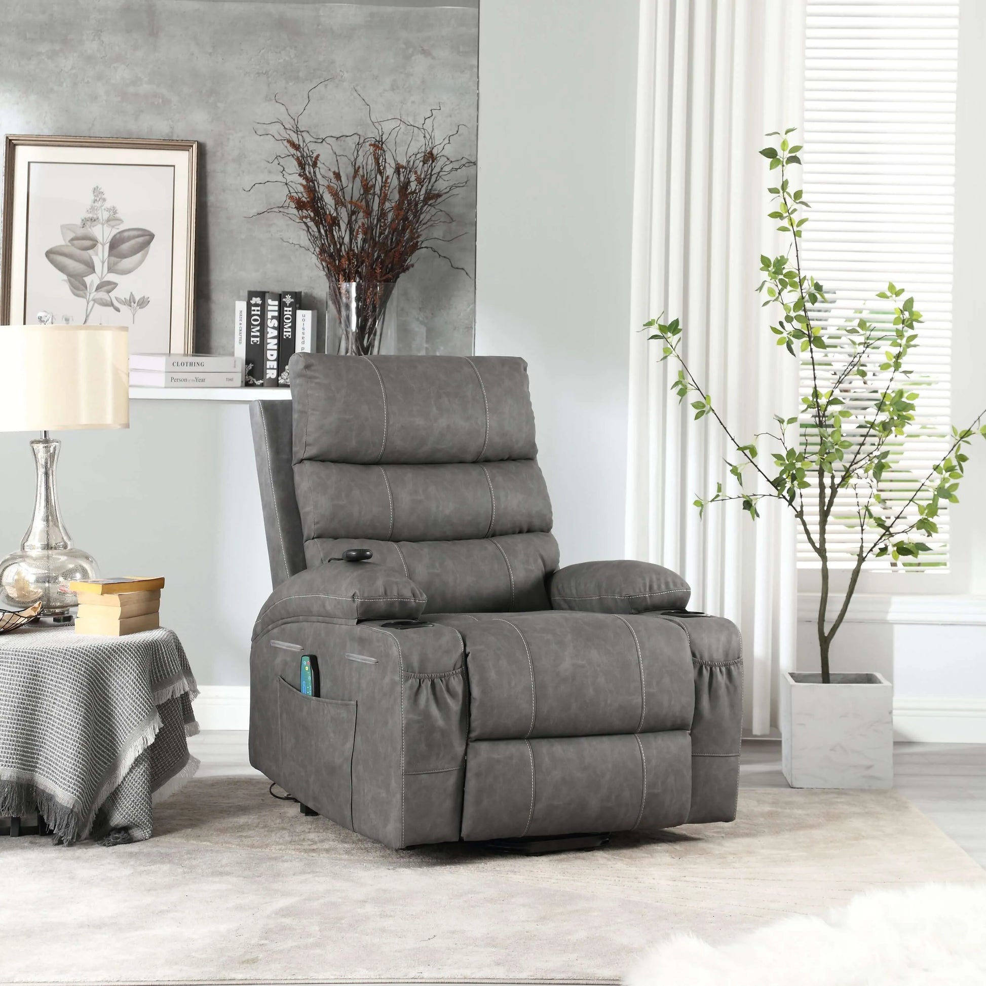 Gray faux leather power lift recliner chair in living room setting with table, lamp and plant