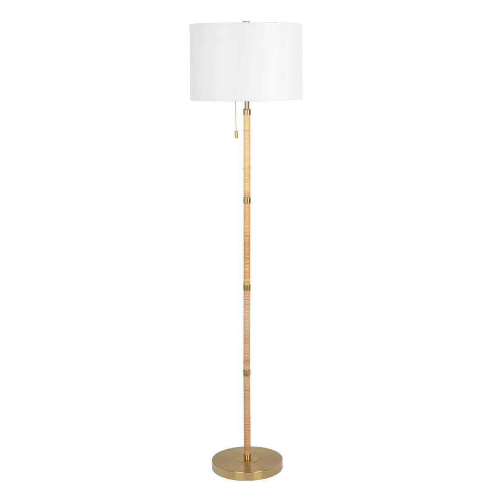 Floor lamp with a white shade and brass base on a white background
